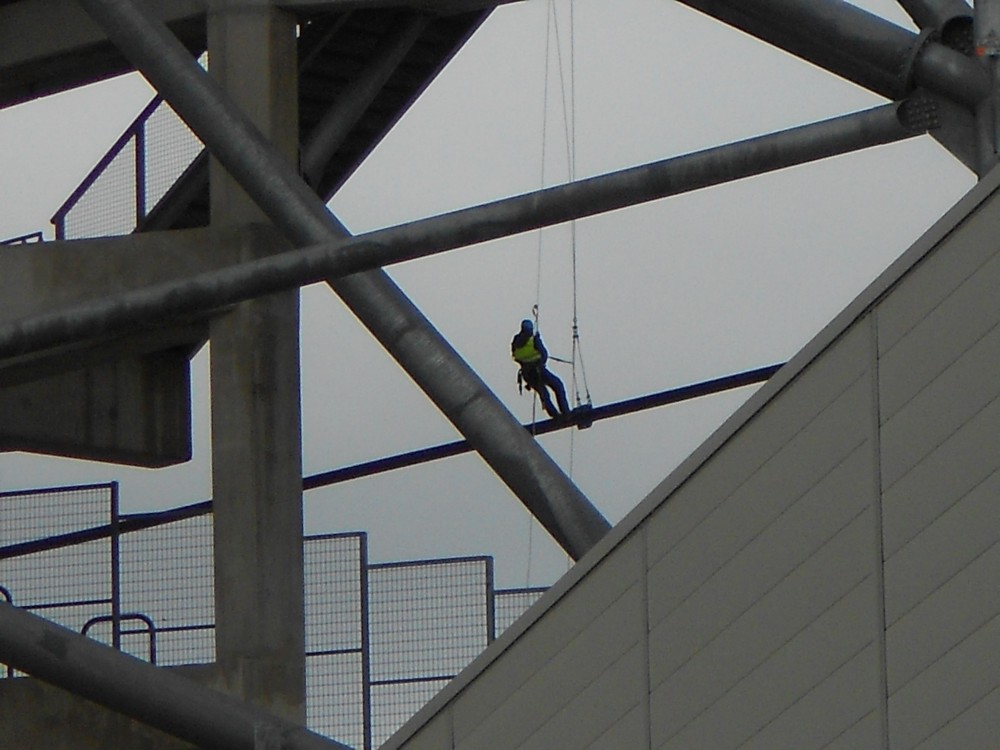 Un alpiniste en plein boulot sur la câble.