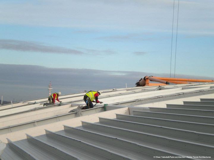 Les alpinistes posent les filets de protection sur les fléaux hauts du toit du Grand Stade.jpg